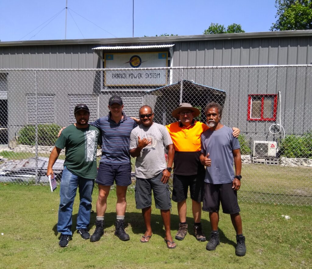 Remote island power station Palau showing happy locals and project team members